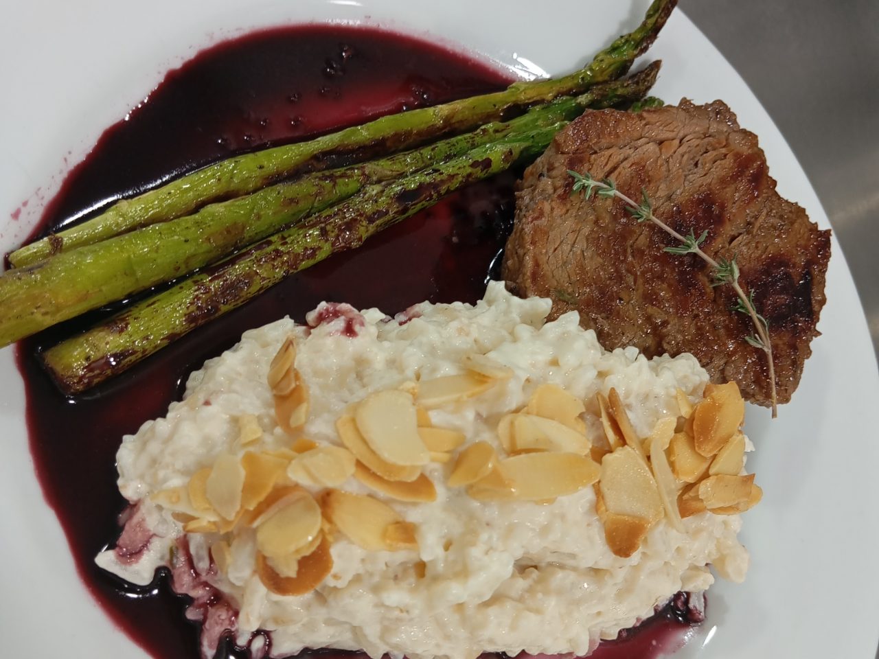 Arroz piamontese de cogumelos, amêndoas laminadas, aspargos salteados e filé mignon com redução de vinho tinto.