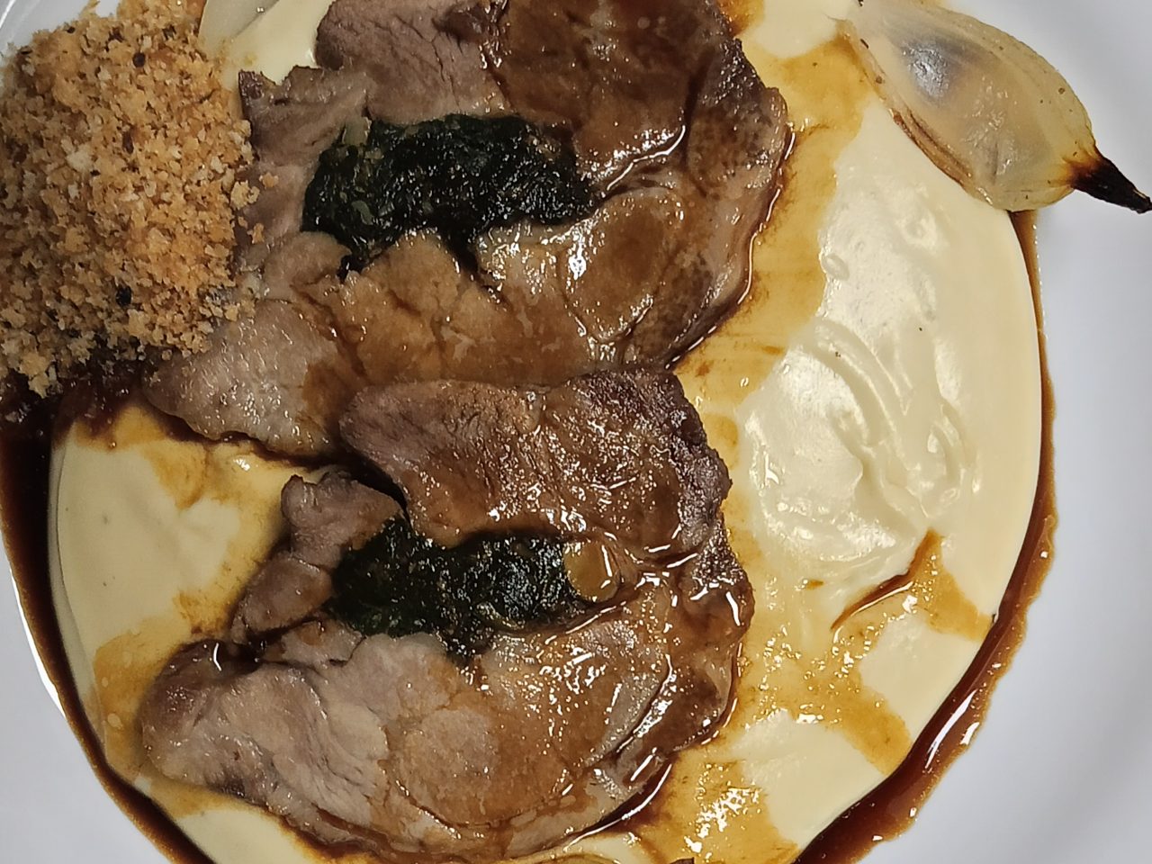 Copa lombo recheada com espinafre e castanha do Pará com purê com queijo, farofa de pão e demi glace de cerveja preta 